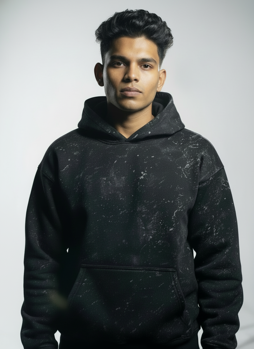Man wearing a black hoodie against a gray background